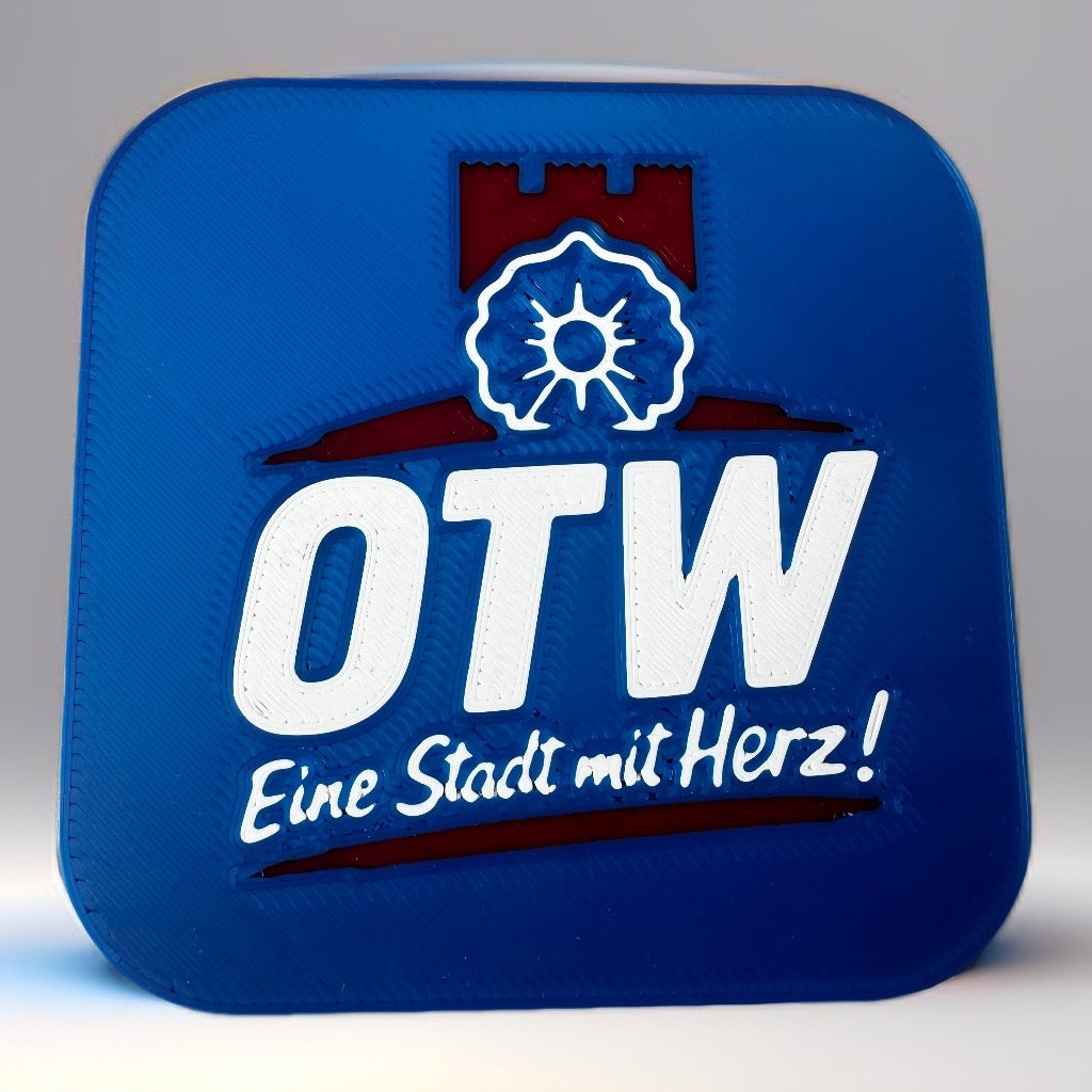 Blauer OTW-Kühlschrankmagnet mit weißem Schriftzug „Eine Stadt mit Herz!“ und rotem Ottweiler Stadtmotiv